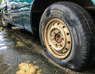 Flat Tire of an old car on the road