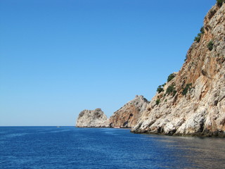 Fototapeta premium The blue sea with beautiful brown rocks with the ruins of an old fortress. Turkey, Alanya