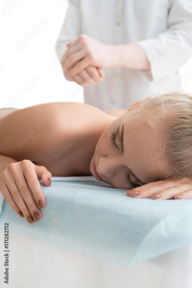 Wall mural Male massagist making massage to blonde in spa