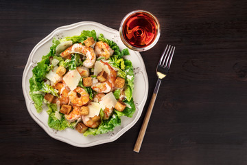 Overhead photo of shrimp Caesar salad with rose wine