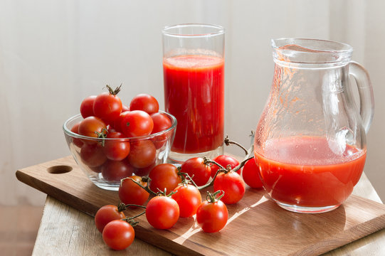 Ripe Cherry Tomatoes And Fresh Tomato Juice Stand On The Kitchen Table