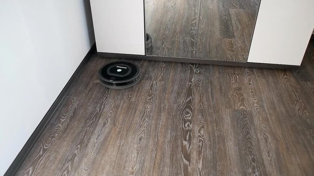 The robot vacuum cleaner removes the floor covered with a laminate, rotating in a spiral and in an arbitrary route
