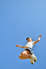 青空でジャンプする女の子