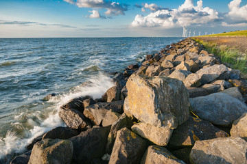 Fototapeta na wymiar The polder dike with stone bollards along the Ijsselmeer at Flevoland