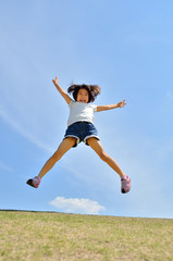 青空でジャンプする女の子