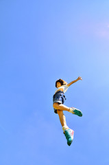 Obraz na płótnie Canvas 青空でジャンプする女の子