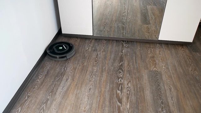 Robot vacuum cleaner is cleaning in a furnished room