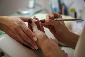 Obraz na płótnie Canvas Close-up of female hands being manicured at a beauty salon.