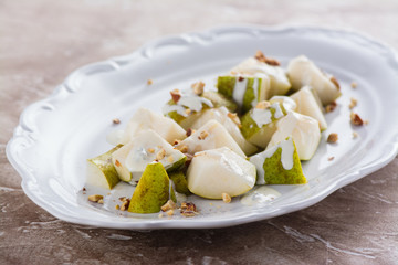 Delicious salad with pear, blue cheese sauce and almonds