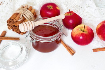 honey spoon, jar of honey, apples and cinnamon on a wooden background in a rustic style (toning)