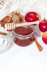 Apples with honey jar on white wooden table