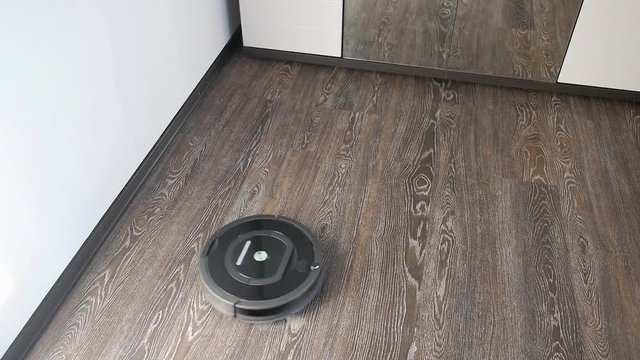 Robot vacuum cleaner is cleaning in a furnished room