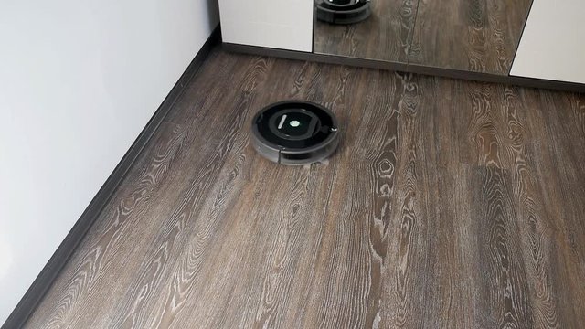 The robot vacuum cleaner removes the floor covered with a laminate, rotating in a spiral and in an arbitrary route