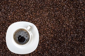 coffee beans background and white cup with hot drink