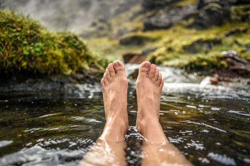 Woman's legs bathing in a hot spring in the Landmannalaugar mountains in Iceland.