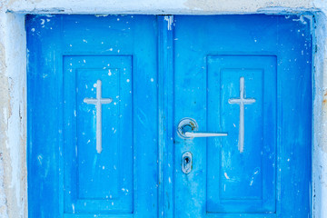 Cross carved on orthodox church door in Oia, Santorini.