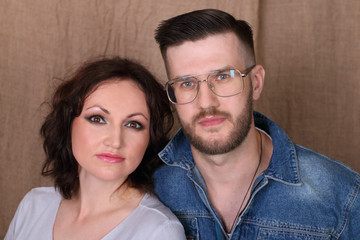 Obraz premium Happy young woman and man in glasses pose together in studio