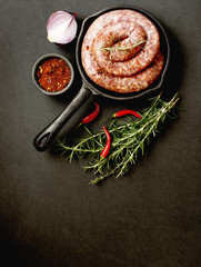 raw beef sausages on a cast-iron pan, selective focus