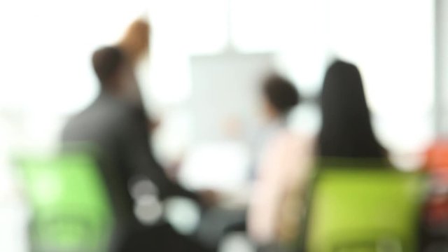 Blured footage of team work in modern office. Rear view of teamwork of coworkers in the meeting room.