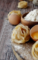 Uncooked pasta with flour on the table, selective focus
