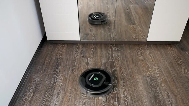 The robot vacuum cleaner removes the floor covered with a laminate, rotating in a spiral and in an arbitrary route