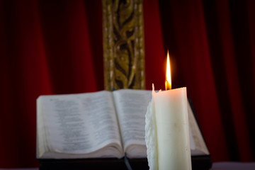 Bible with candles in the background. Low light scene.