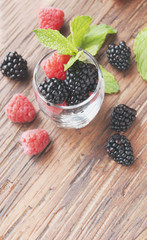 black berries and raspberries in a glass cup