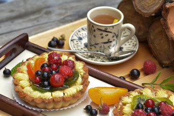 Small fruit tart with redcurrant, blackcurrant, kiwi and tea - tasty dessert