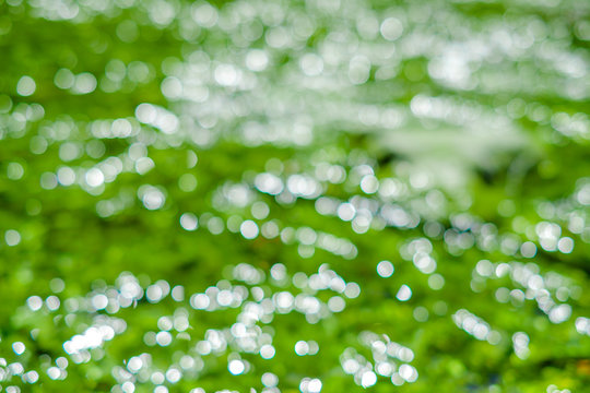 Flou lumineux: r&eacute;flets de soleil sur une surface de l'eau 