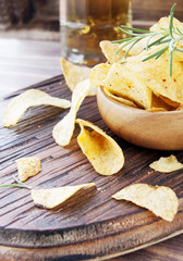 Chips in a wooden bowl and beer