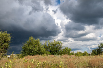 Obraz premium Summer landscape with dramatic cloudy sky