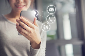 CONTACT US, Hand of Woman holding mobile smartphone with ( mail,phone,email ) icon. cutomer support concept