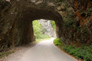 the mountain road passes through a stone tunnel