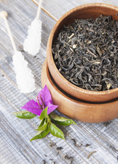 leaf green tea in wooden bowl with sugar on stick
