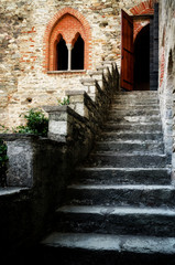 Fototapeta na wymiar Antique castle staircase with double lancet window and entrance door at the top