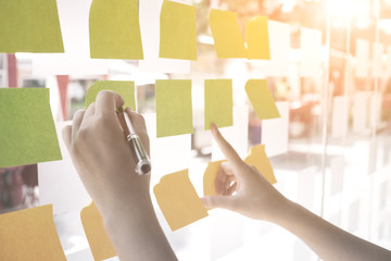 Hands using post it paper note to memo or share ideas.