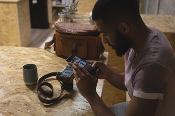 High angle view of young man photographing camera with mobile