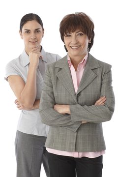 Two women standing arms crossed smiling