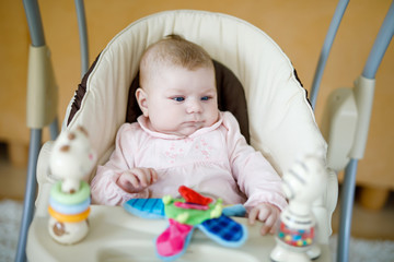 Cute adorable newborn baby sitting in swing