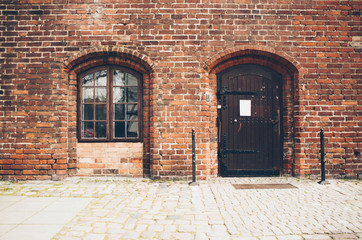 Fototapeta na wymiar old brick wall with door and window