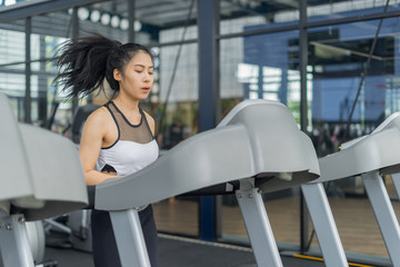 Fitness woman running with exercise-machine in gym