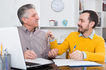 Obraz premium Mature man and agent sign rental agreement