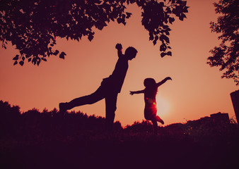 Fototapeta na wymiar father and little daughter doing yoga at sunset