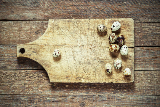 quail eggs on an old board on a wooden background