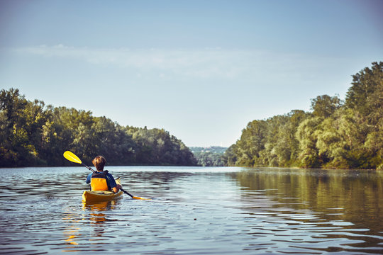 A canoe trip along the river along the forest in summer.
