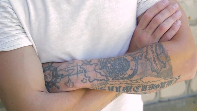 tattooed men hands folded cross