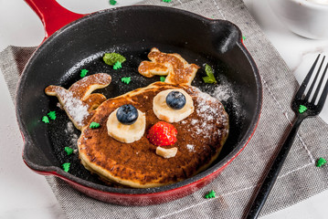 Funny food for Christmas. Kids breakfast pancake decorated like reindeer, with hot chocolate with marshmallow, white table copy space top view