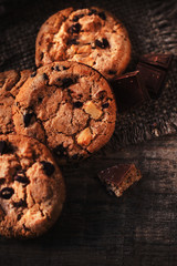 Chocolate chip cookie  on burlap and rustic wooden table. Freshly baked choco cookie close up