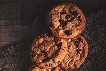 Chocolate chip cookie  on burlap and rustic wooden table. Freshly baked choco cookie close up