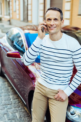 Positive delighted man putting a cell phone to his ear